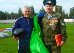 В День Воздушного флота - разноцветные купола парашютов и флаг России в небе над Арсеньевом